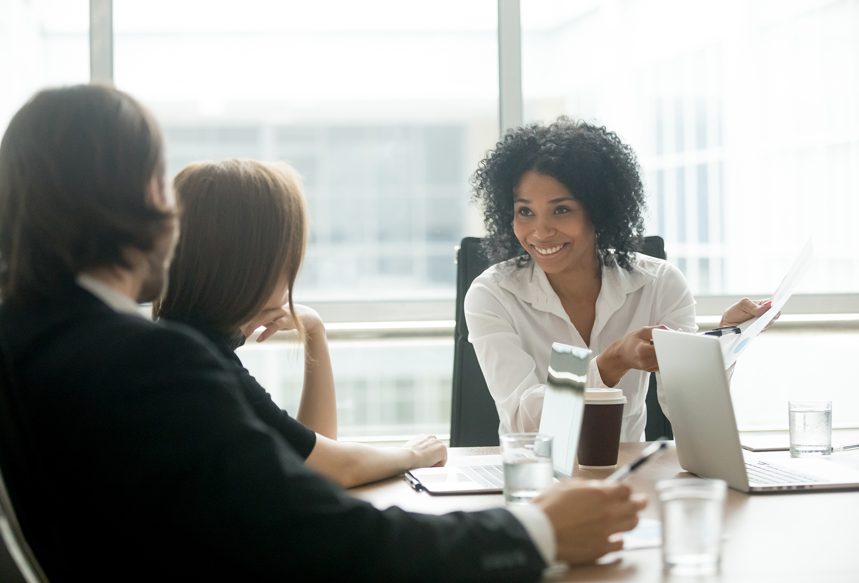 hree nonprofit professionals sit at a conference table to discuss their fundraising feasibility study process